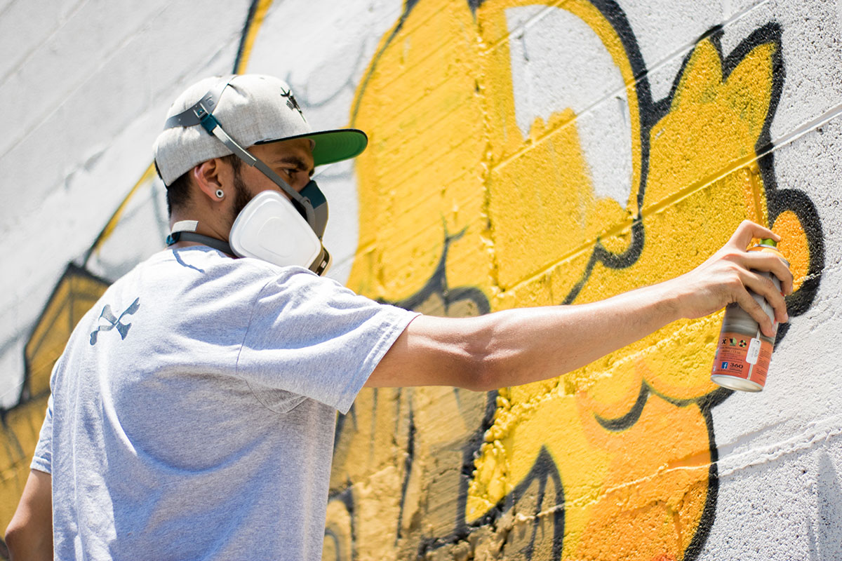 Une personne faisant un graffiti sur un mur blanc