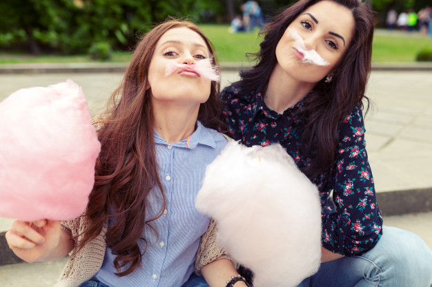 femmes jouant avec des barbes à papa